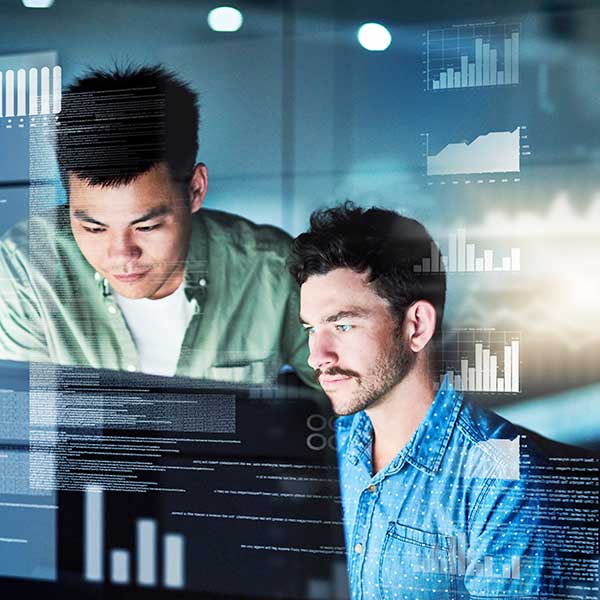 two young male computer programmers working at office